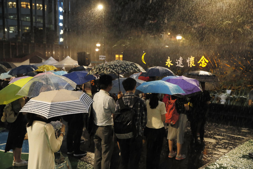 Attendees take part in a public memorial for Marco Leung, 35-year-old man, who fell to his death weeks ago after hanging a protest banner against an extradition bill, in Hong Kong, Thursday, July 11, 2019. The parents of a Hong Kong man who plunged to his death after putting up banners against divisive extradition bills have urged young people to stay alive to continue their struggle. (AP Photo/Kin Cheung)