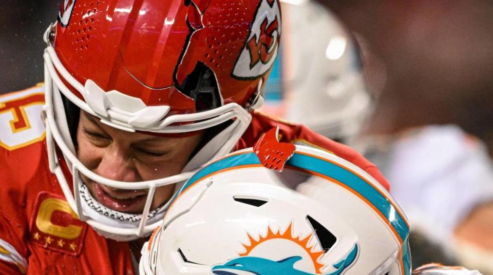 The helmet of Kansas City Chiefs quarterback Patrick Mahomes (15) breaks while being hit by Miami Dolphins safety DeShon Elliott (21) on a run in the third quarter Saturday, Jan. 13, 2024, at GEHA Field at Arrowhead Stadium.