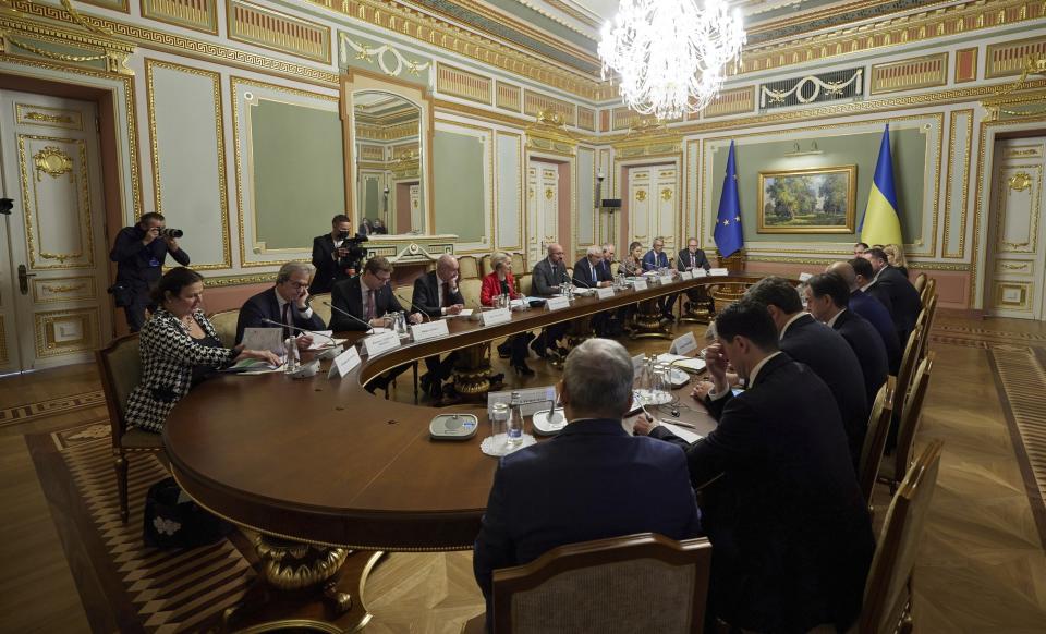 Ukrainian President Volodymyr Zelenskyy, sitting at center right with back to camera, and European Commission President Ursula von der Leyen, center left in red jacket, attend a Ukraine EU summit in Kyiv, Ukraine, Tuesday, Oct. 12, 2021. The 23rd summit between the European Union and Ukraine is held in Kyiv. (Ukrainian Presidential Press Office via AP)