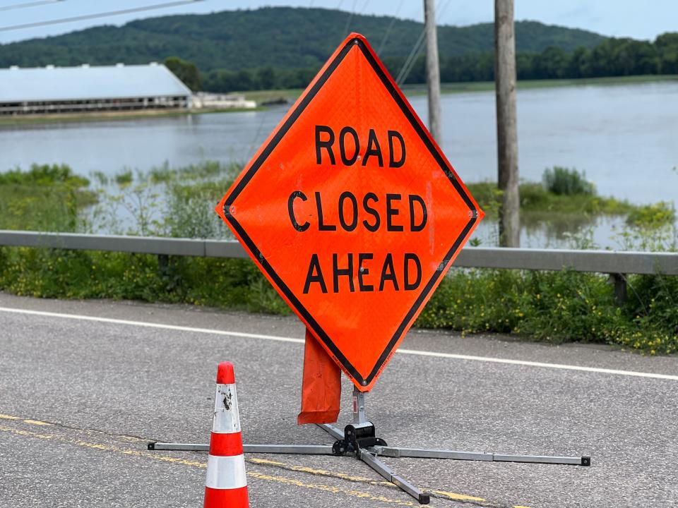 A road closure sign on West Main St. in Richmond on July 11, 2023. The waters in the background cover a field of hay and corn crop.