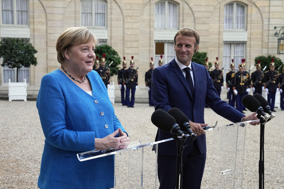 France's President Emmanuel Macron, right, and German Chancellor Angela Merkel give a press conference prior to a meeting at the Elysee Palace, in Paris, Thursday, Sept. 16, 2021. (AP Photo/Michel Euler)