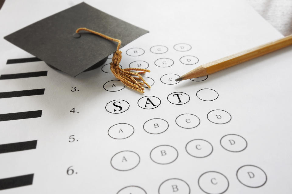 SAT test with pencil and mortar board graduation cap