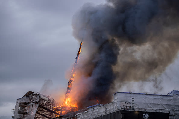 The tower of the historic Boersen stock exchange collapses as the building is on fire in central Copenhagen, Denmark on April 16, 2024. The building, one of the oldest in the Danish capital, was undergoing renovation work when in the morning it caught fire, whose cause was yet unknown. The building was erected in the 1620s as a commercial building by King Christian IV and is located next to the Danish parliament. (Photo by Ida Marie Odgaard / Ritzau Scanpix / AFP) / Denmark OUT (Photo by IDA MARIE ODGAARD/Ritzau Scanpix/AFP via Getty Images)