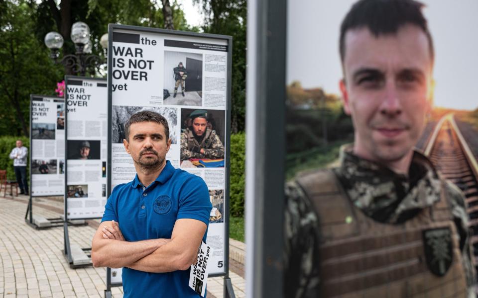 A man reads from The War Is Not Over exhibition stands in Taras Shevchenko Park on June 23, 2022 in Kyiv, Ukraine. The exhibition showcases the work of journalists who have been killed, injured, come under fire, captured or persecuted since the beginning of Russia's February 24 invasion of Ukraine. -  Alexey Furman/Getty Images