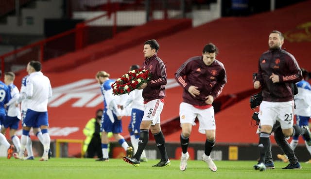 Manchester United captain Harry Maguire carries a wreath in memory of the Munich air disaster before kick-off