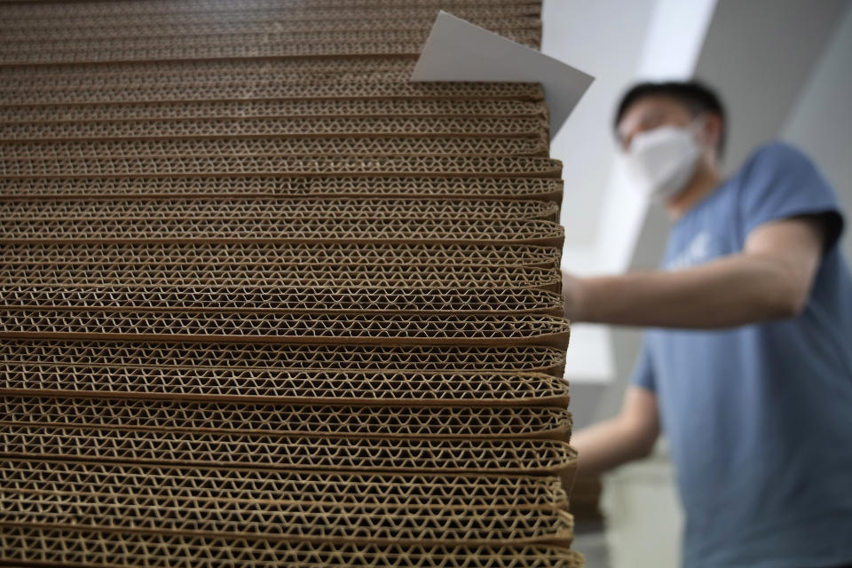 A pile of cardboard is placed at the factory of LifeArt to make paper coffin in Hong Kong, Friday, March 18, 2022. Hong Kong is running short of coffins during its deadliest outbreak of the coronavirus pandemic. LifeArt, a company in Hong Kong is trying to make an alternative, cardboard coffin, which it says is environmentally-friendly. (AP Photo/Kin Cheung)