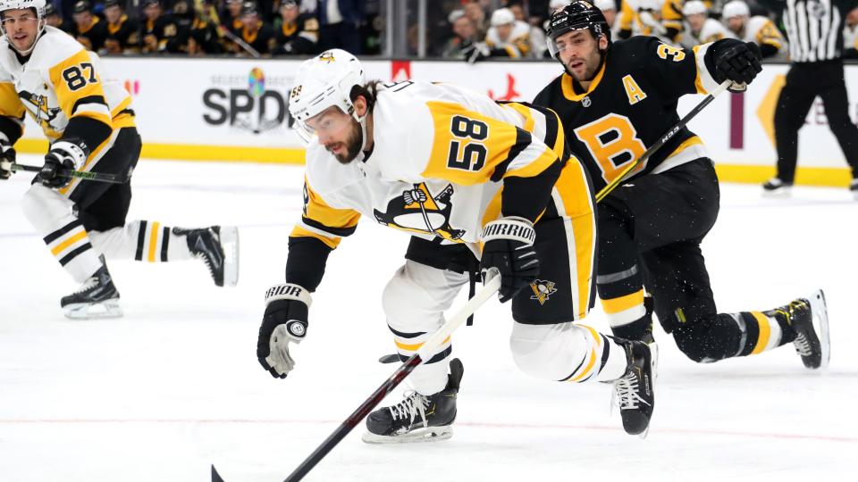 BOSTON, MASSACHUSETTS - JANUARY 16: Patrice Bergeron #37 of the Boston Bruins defends Kris Letang #58 of the Pittsburgh Penguins during the first period at TD Garden on January 16, 2020 in Boston, Massachusetts. (Photo by Maddie Meyer/Getty Images)