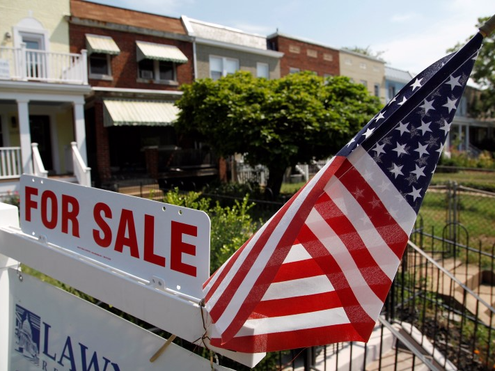 A U.S. flag decorates a for-sale sign at a home in the Capitol Hill neighborhood of Washington, August 21, 2012. REUTERS/Jonathan Ernst