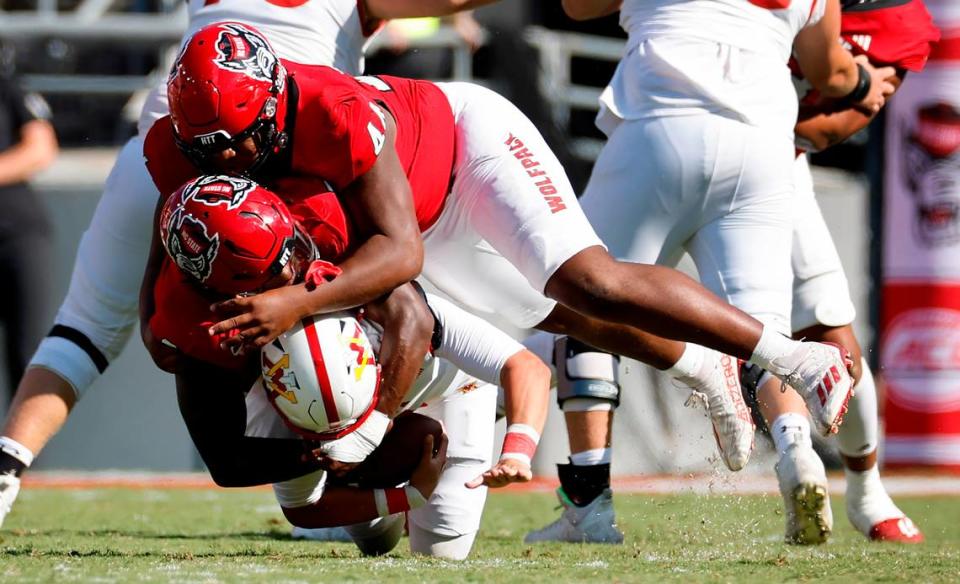 N.C. State linebacker Jaylon Scott (2) and defensive lineman Brandon Cleveland (44) sack Virginia Military Institute quarterback Collin Shannon (1) during the second half of the Wolfpack’s 45-7 victory over VMI at Carter-Finley Stadium in Raleigh, N.C., Saturday, Sept. 16, 2023.