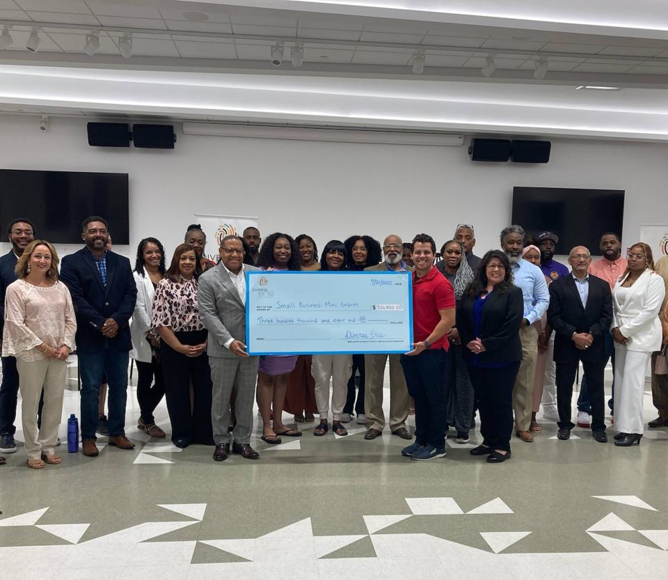 Diverse Erie Chief Administrative Officer Gary Lee and Board Chairman Ricardo Escajadillo hold a check for $300,800 awarded to 29 minority-owned small businesses in Erie County. The check presentation was held July 21 at the Erie Center for Arts and Technology.