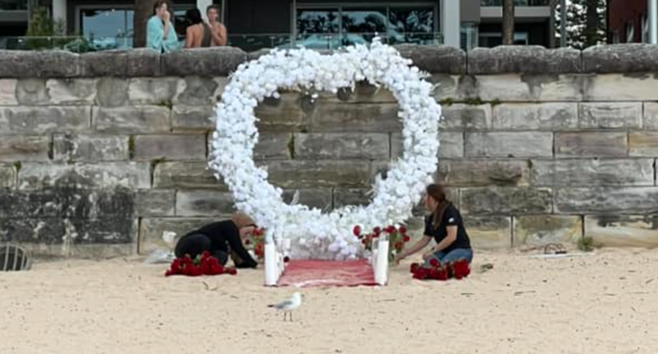 People setting up a romantic Valentine's Day proposal on Manly Beach. 