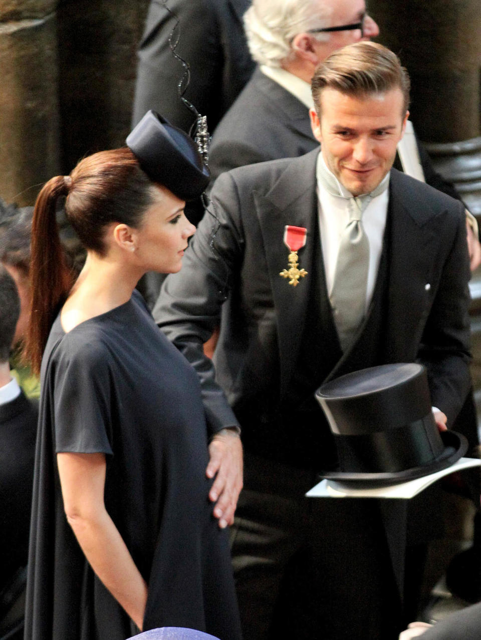 David Beckham pats his wife Victoria's baby bump as they arrive at Westminster Abbey in London, for the royal wedding of Britain's Prince William and Kate Middleton, on April 29, 2011. (Jon Bond / AFP via Getty Images)