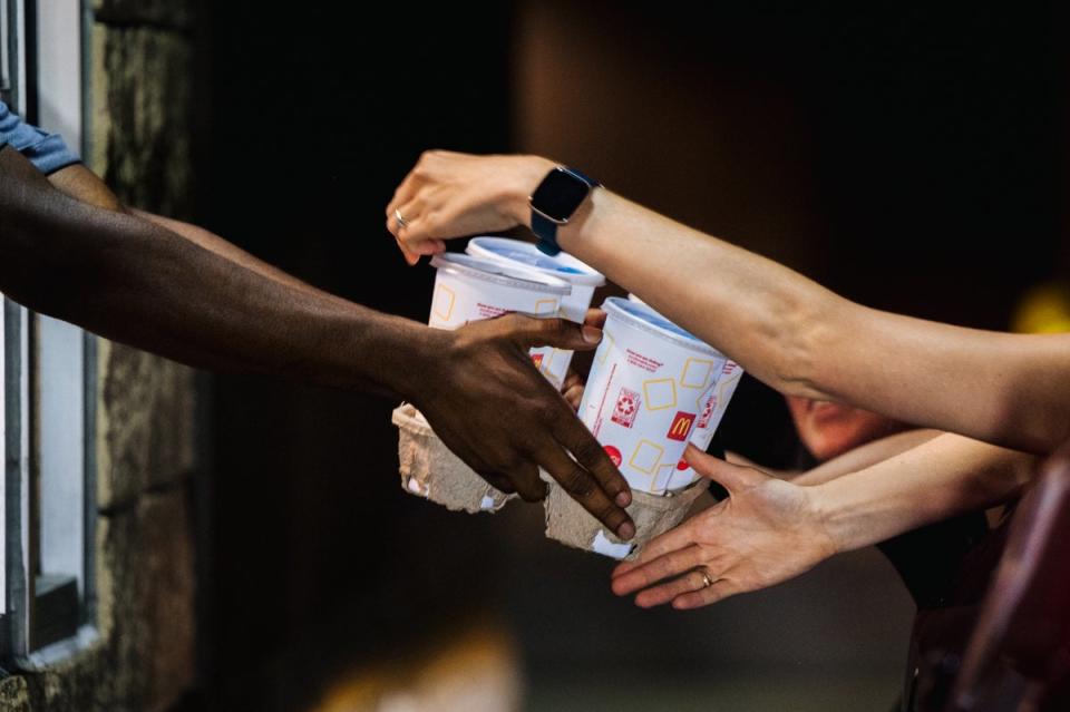 A McDonald’s employee hands a customer drinks. Individual franchisees may choose to eliminate free refills, the company said (Getty Images)