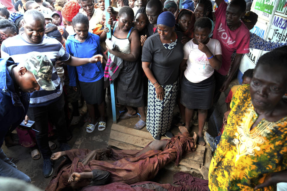 Residents gather around the covered body of a woman retrieved from a house, after heavy rain in the Mathare slum of Nairobi, Kenya, Wednesday, April 24, 2024. Heavy rains pounding different parts of Kenya have led to dozens of deaths and the displacement of tens of thousands of people, according to the U.N., citing the Red Cross. (AP Photo/Brian Inganga)
