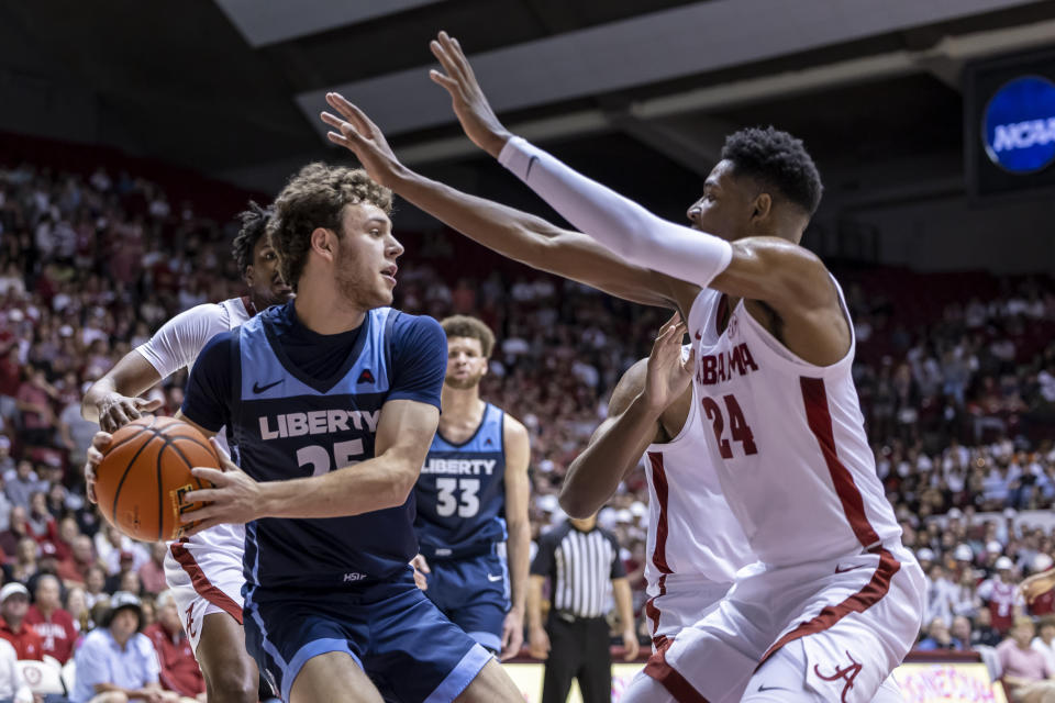 Alabama forward Brandon Miller (24) defends against Liberty forward Zach Cleveland (25) during the first half of an NCAA college basketball game, Friday, Nov. 11, 2022, in Tuscaloosa, Ala. (AP Photo/Vasha Hunt)