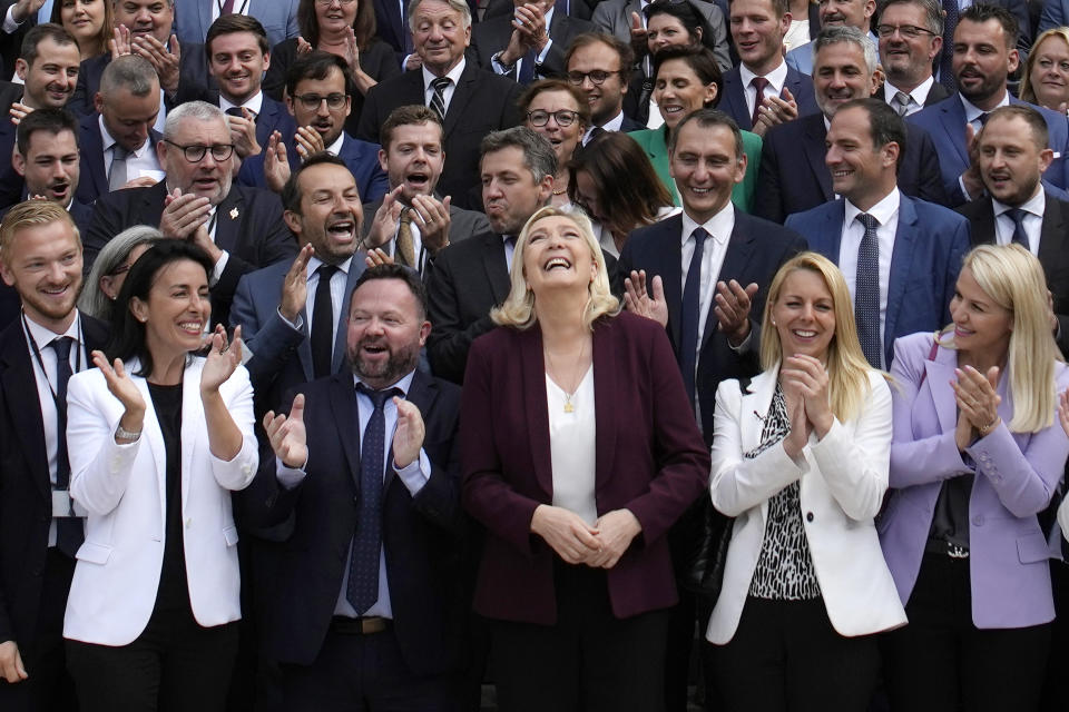 FILE - French far-right leader Marine Le Pen, center, and National Rally party newly elected parliament members pose at the National Assembly, June 22, 2022 in Paris. France's allies closely watched Sunday's elections that led Macron's alliance to win the most seats but lose its straight majority in the National Assembly. The situation makes French President Emmanuel Macron 's life significantly harder at home.Yet it is not expected to destabilize his international agenda in an immediate future. (AP Photo/Christophe Ena, File)