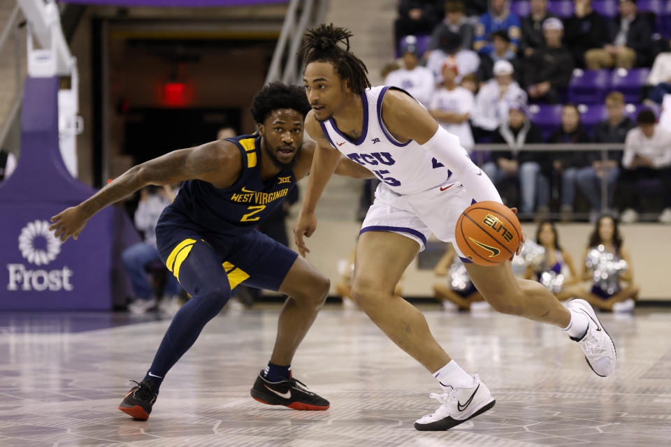 TCU forward Chuck O'Bannon Jr. (5) works to the basket as West Virginia's Kobe Johnson (2) defends in the first half of an NCAA college basketball game, Tuesday, Jan. 31, 2023, in Fort Worth, Texas. (AP Photo/Ron Jenkins)