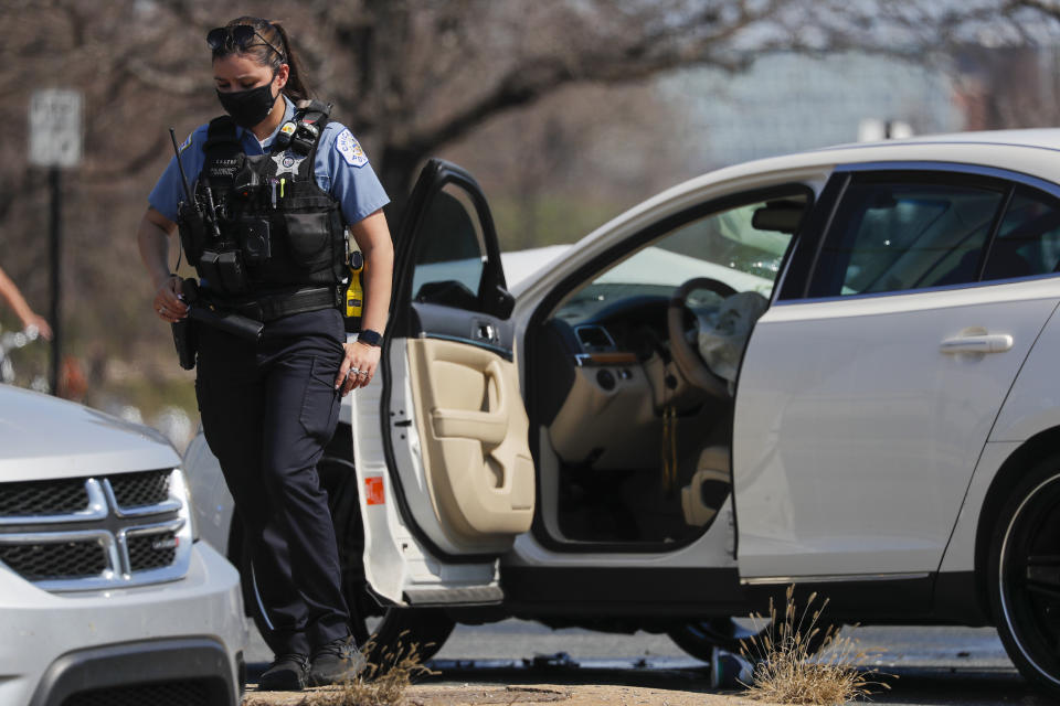 A Chicago police officer stands on the scene of a shooting where a 2-year-old boy was shot in the head while he was traveling inside a car near Grant Park, Tuesday, April 6, 2021. (Jose M. Osorio/Chicago Tribune via AP)