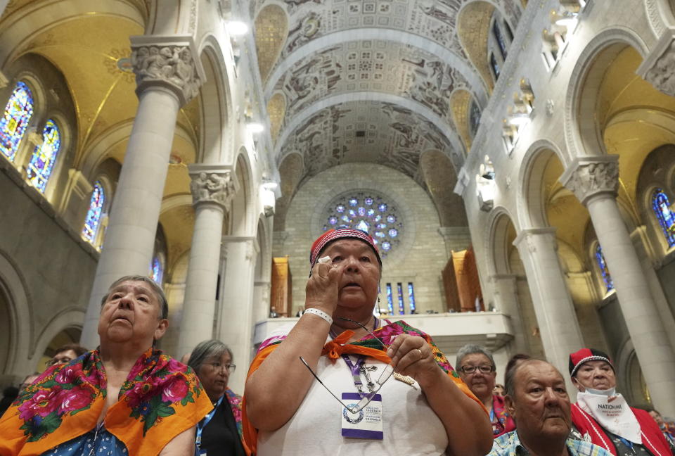 An Indigenous woman wipes a tear during a mass with Pope Francis at the Basilica of Sainte-Anne-de-Beaupré in Ste-Anne-de-Beaupré, Quebec, Thursday, July 28, 2022. Pope Francis crisscrossed Canada this week delivering long overdue apologies to the country's Indigenous groups for the decades of abuses and cultural destruction they suffered at Catholic Church-run residential schools. (Nathan Denette/The Canadian Press via AP)