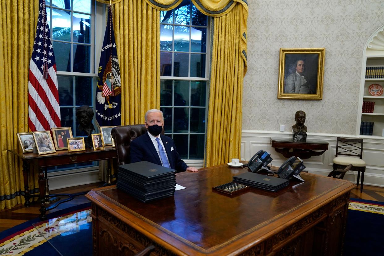 President Joe Biden signs his first executive orders in the Oval Office of the White House on Wednesday, Jan. 20, 2021, in Washington.