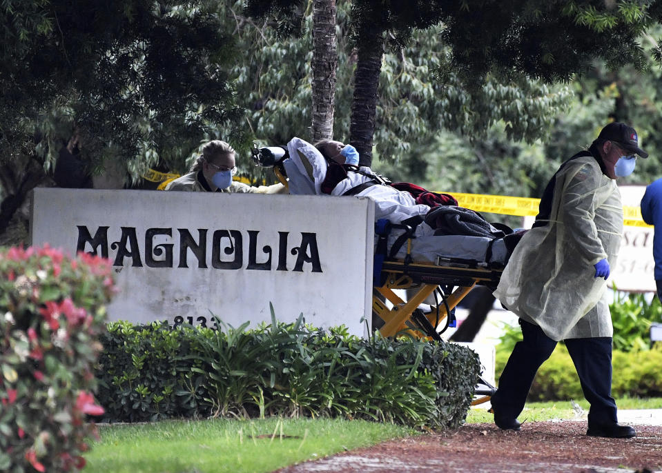 A patient at the Magnolia Rehabilitation and Nursing Center in Riverside, Calif., is evacuated to a waiting ambulance Wednesday, April 8, 2020. Employees of the facility, with 39 confirmed cases of the novel coronavirus, did not show up to care for sick patients two days in a row, Riverside County officials said. (Will Lester/The Orange County Register via AP)