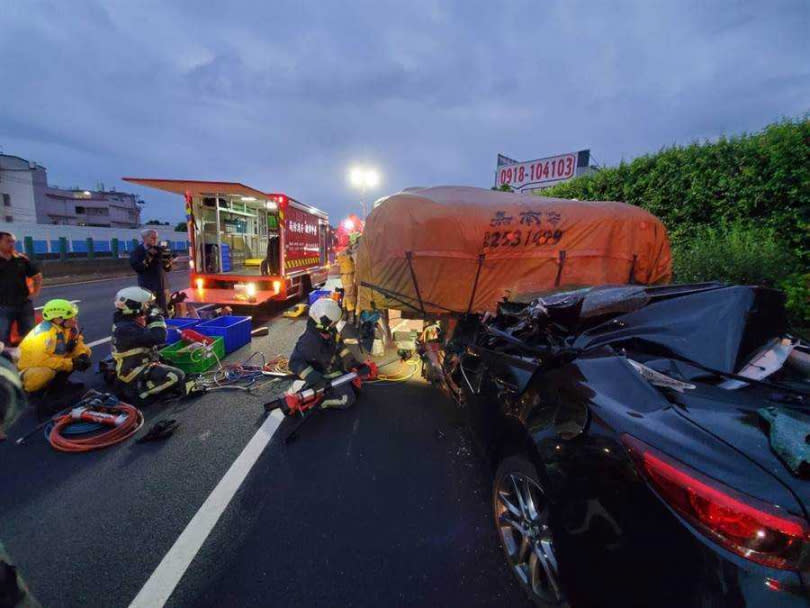 黑色轎車行經國1北上173公里，從後方追撞大貨車車斗，駕駛受困變形車內慘死。（圖／台中市消防局提供）