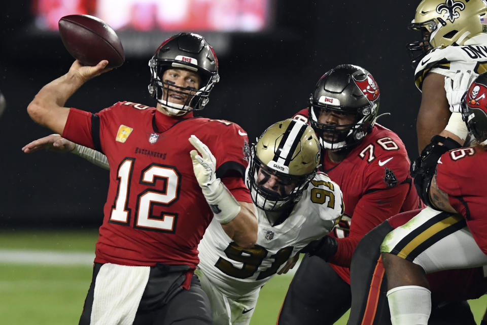 Tampa Bay Buccaneers quarterback Tom Brady (12) is pressured by New Orleans Saints defensive end Trey Hendrickson (91) as he throws a pass during the second half of an NFL football game Sunday, Nov. 8, 2020, in Tampa, Fla. (AP Photo/Jason Behnken)