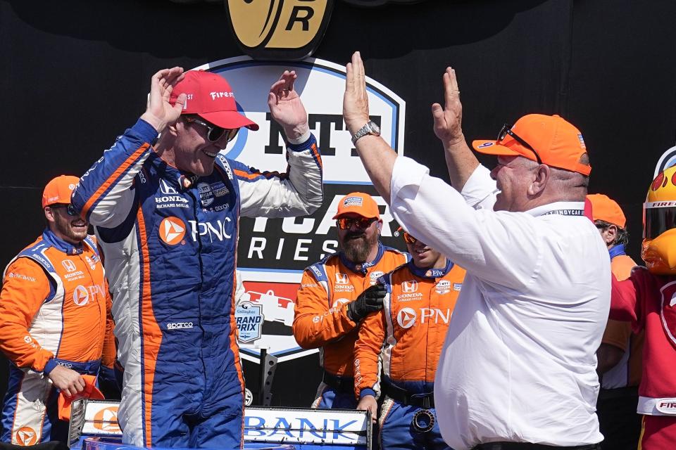 Scott Dixon, of New Zealand, celebrates with car owner Chip Ganassi after winning the IndyCar Indianapolis GP auto race at Indianapolis Motor Speedway, Saturday, Aug. 12, 2023, in Indianapolis. (AP Photo/Darron Cummings)