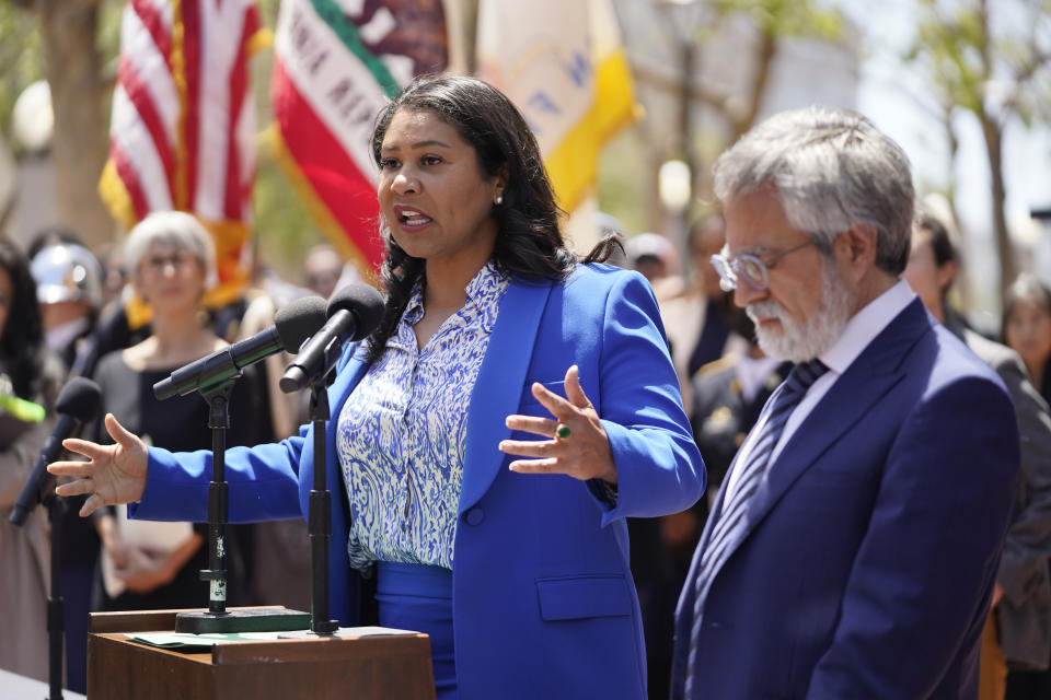 San Francisco Mayor London Breed speaks during a rare outdoor meeting of the Board of Supervisors at UN Plaza in San Francisco, Tuesday, May 23, 2023. Mayor Breed attempted to answer questions from supervisors demanding her administration do more to shut down open-air drug dealing, but the meeting had to be moved indoors to City Hall because of disruptions. Listening at right is Board of Supervisors President Aaron Peskin. (AP Photo/Eric Risberg)