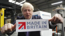 Britain's Prime Minister Boris Johnson holds a sign he took off the packaging of a washing machine at Ebac electrical appliances manufacturer during a General Election campaign trail stop in Newton Aycliffe, England, Wednesday, Nov. 20, 2019. Britain goes to the polls on Dec. 12. (AP Photo/Frank Augstein, Pool)