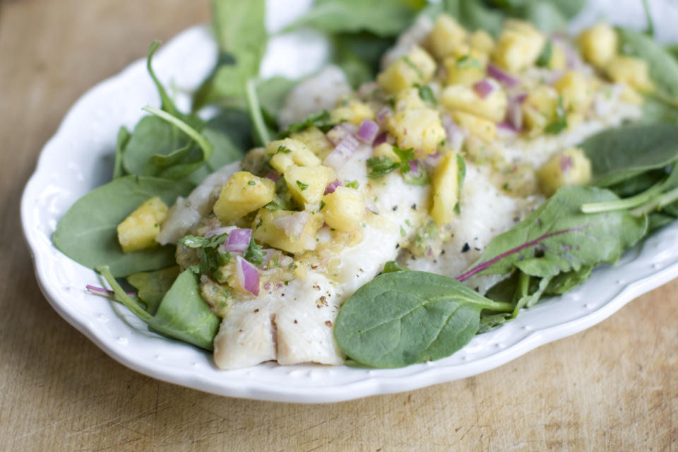 This Dec. 2, 2013 photo shows baked haddock with pineapple mint salsa in Concord, N.H. Baked white fish is a fast and healthy way to get dinner on the table. The secret to getting a good tasting baked white fish, without adding tons of fat and calories or rendering it a tasteless hunk of protein, is all in how you dress it. (AP Photo/Matthew Mead)