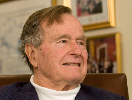 FILE PHOTO - Former President George H.W. Bush smiles as he listens to Republican presidential candidate Mitt Romney speak as he met with Bush to pick up his formal endorsement in Houston in this March 29, 2012 file photo. REUTERS/Donna Carson/File Photo