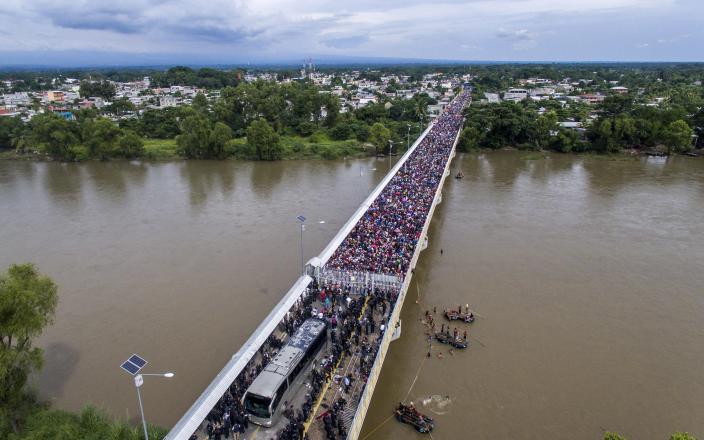 <p>Aerial view of a Honduran migrant caravan heading to the U.S., as it is stopped at a border barrier on the Guatemala-Mexico international bridge in Ciudad Hidalgo, Chiapas state, Mexico, on Oct. 19, 2018. (Photo: Pedro Pardo/AFP/Getty Images) </p>