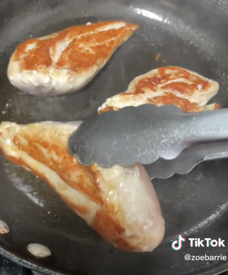 Turning seared chicken that's golden brown on one side