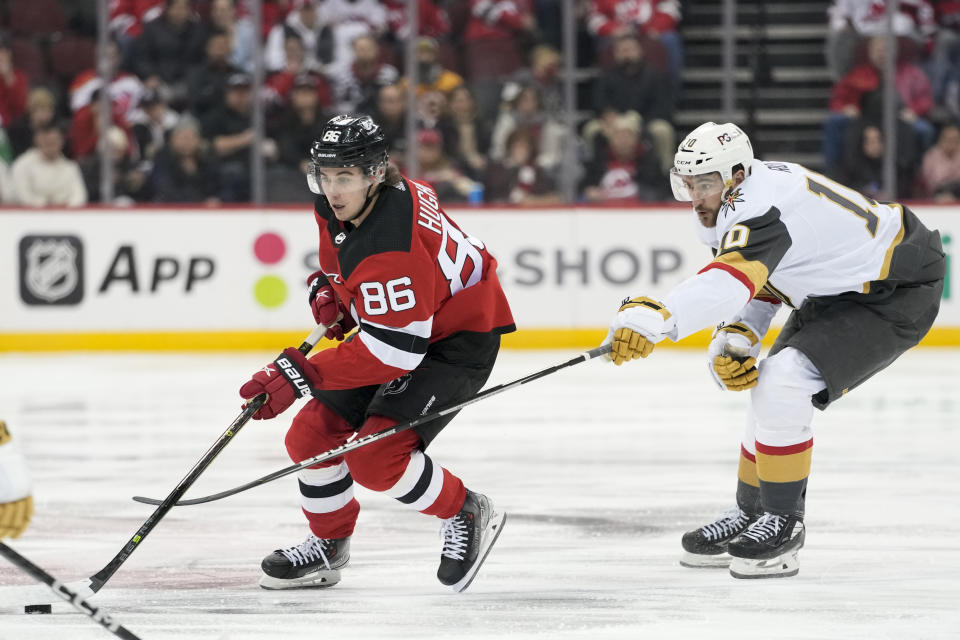 New Jersey Devils center Jack Hughes (86) skates past Vegas Golden Knights center Nicolas Roy (10) during the second period of an NHL hockey game, Tuesday, Jan. 24, 2023, in Newark, N.J. (AP Photo/Mary Altaffer)