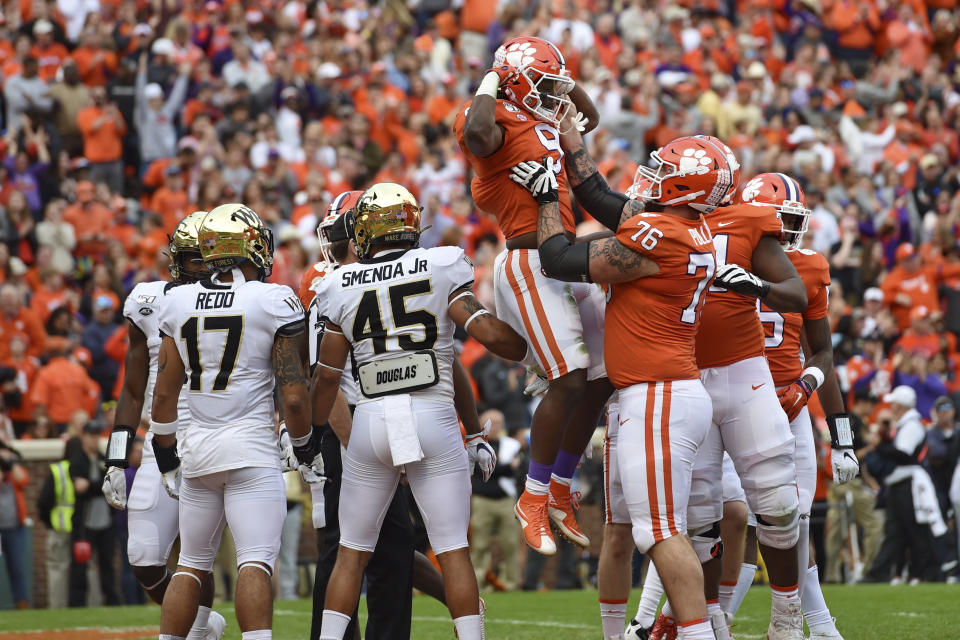 Clemson's Travis Etienne (9) is lifted while celebrating a touchdown with Sean Pollard (76) during the first half of an NCAA college football game against Wake Forest, Saturday, Nov. 16, 2019, in Clemson, S.C. (AP Photo/Richard Shiro)