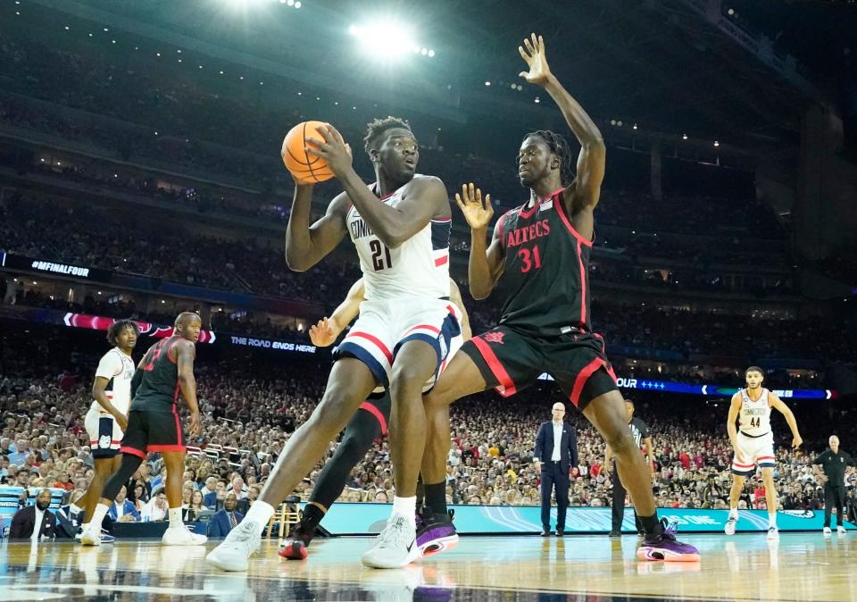 UConn forward Adama Sanogo controls the ball and looks for positioning against San Diego State forward Nathan Mensah during Monday night's NCAA championship game. Texas may get to face the Huskies during an early-season tournament.