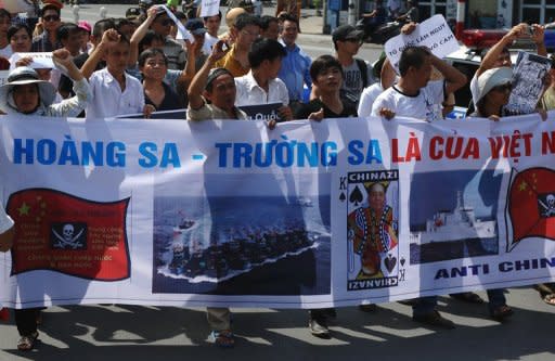 Vietnamese shout anti-China slogans and hold placards during a march towards the Chinese embassy in Hanoi on July 22, 2012. Beijing will establish a military garrison on a group of disputed islands in the South China Sea, China's defence ministry said Monday, a move likely to provoke further tensions with its neighbours