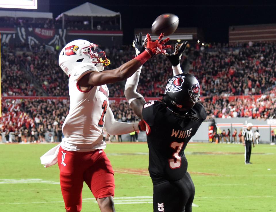 Louisville receiver Jadon Thompson (2) and North Carolina State cornerback Aydan White (3) vie for a pass during the second half.