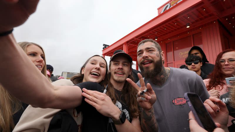 Fans take a selfie with Post Malone during the grand opening celebration of a Raising Cane’s Restaurant, designed by the singer, in Midvale on Thursday, April 13, 2023. Malone recently spoke about his love of living in Cottonwood Heights. 