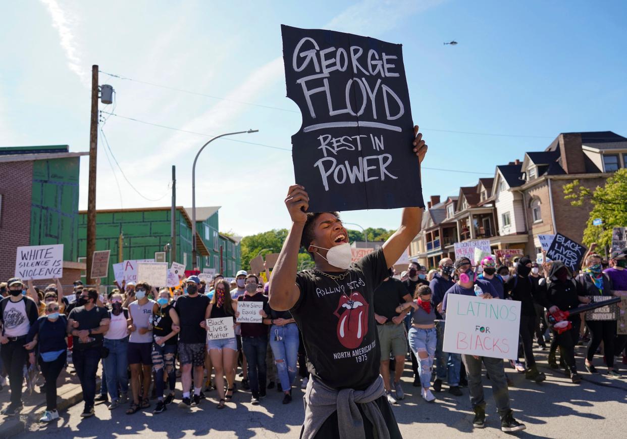 In this Monday, June 1, 2020 photo, Dínico Perry-Ellis leads a chant on Station Street in Pittsburgh, protesting the death of George Floyd, who died after being restrained by Minneapolis police officers on May 25. (Steve Mellon/Pittsburgh Post-Gazette via AP)