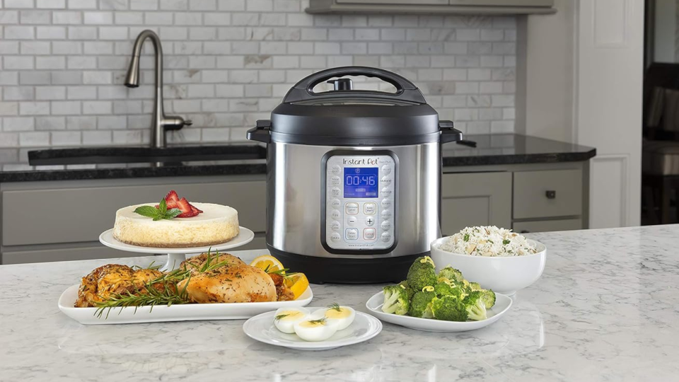 An Instant Pot on a kitchen counter surrounded by various dishes