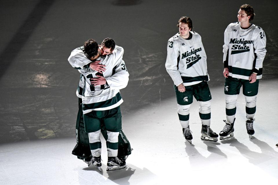 From left, Michigan State's Jeremy Davidson hugs Jon Mor as fellow seniors Reed Lebster, and James Crossman look on during the senior night ceremony after the Spartans win over Ohio State on Saturday, Feb. 24, 2024, at Munn Arena in East Lansing.