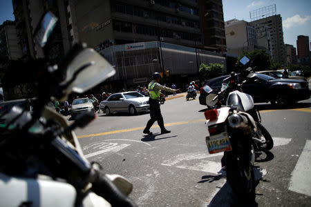 A police officer controls the traffic during a blackout in Caracas, Venezuela March 25, 2019. REUTERS/Carlos Garcia Rawlins