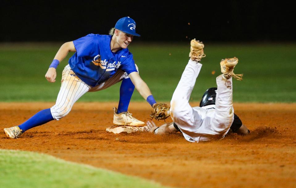 Canterbury Cougars infielder Brayden Habuda (12) tries to apply a tag to Gulf Coast Sharks runner Jackson Geiger (6) during the sixth inning of a game at Gulf Coast High School in Naples on Tuesday, April 2, 2024.