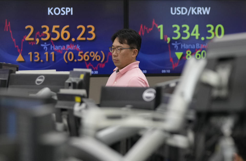 A currency watches monitors near the screens showing the Korea Composite Stock Price Index (KOSPI), left, and the foreign exchange rate between U.S. dollar and South Korean won at the foreign exchange dealing room of the KEB Hana Bank headquarters in Seoul, South Korea, Friday, Nov. 3, 2023. (AP Photo/Ahn Young-joon)