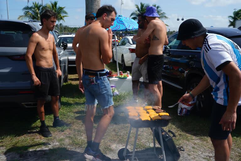 Hinchas argentinos preparan unas hamburguesas antes del partido