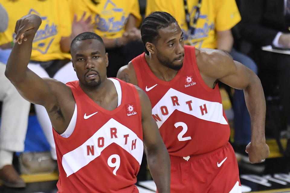 Toronto Raptors center Serge Ibaka (9) celebrates his 3-point basket against the Golden State Warriors, next to forward Kawhi Leonard (2) during the second half of Game 4 of basketball’s NBA Finals, Friday, June 7, 2019, in Oakland, Calif. (Frank Gunn/The Canadian Press via AP)