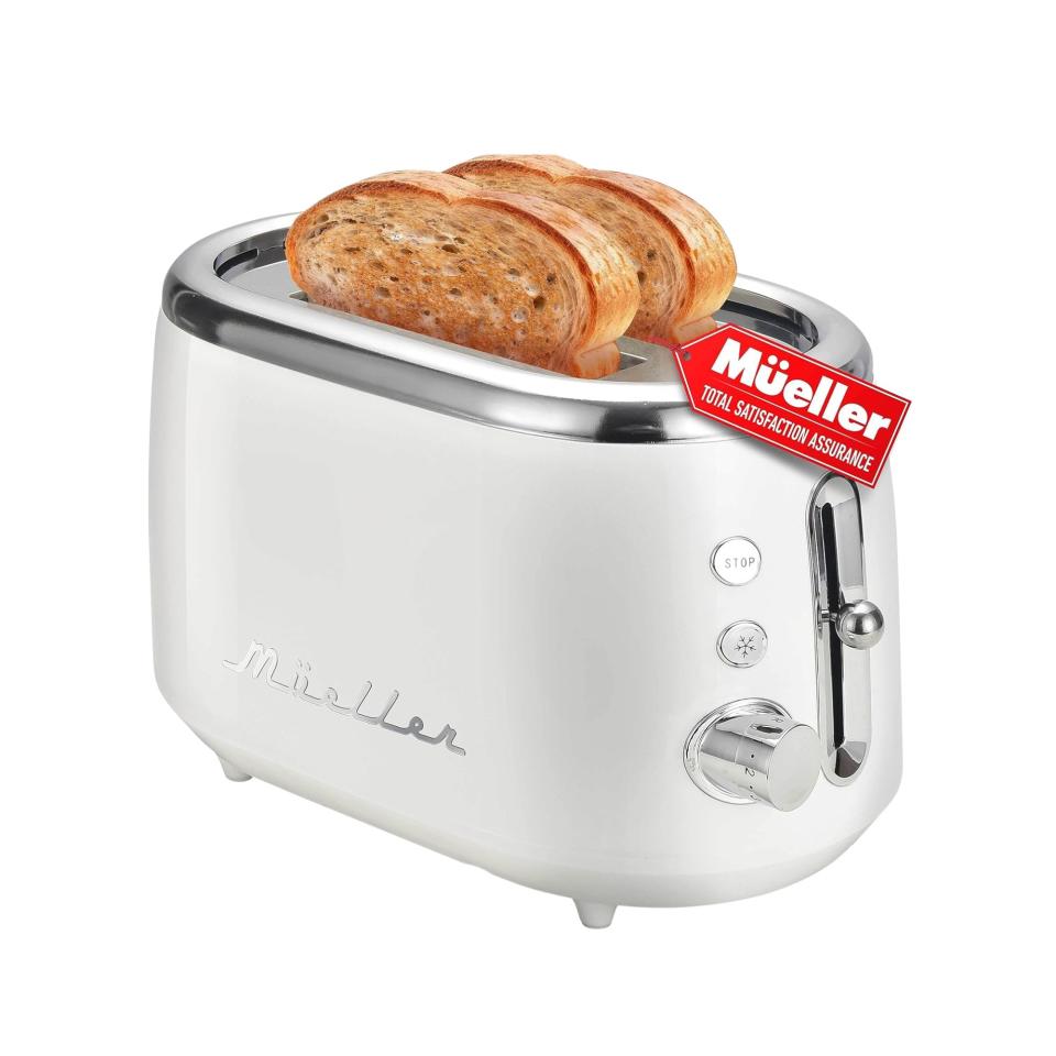 A white retro toaster with a silver top with two slices of toast popping out, silver writing on the side that says 'mueller' and a silver handle