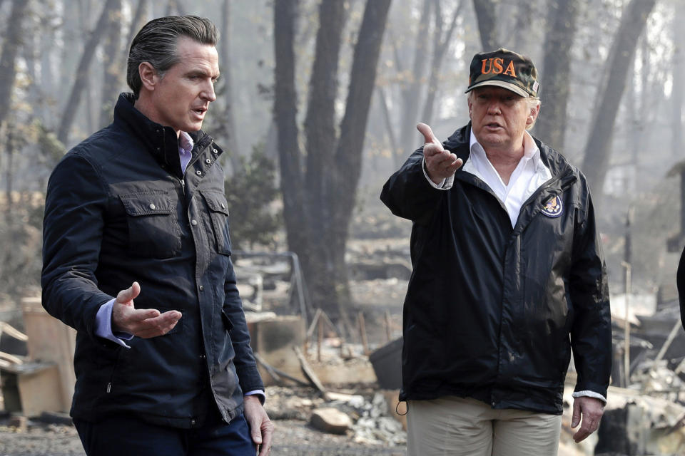 FILE - In this Nov. 17, 2018, file photo, President Donald Trump talks with then California Gov.-elect Gavin Newsom, left, during a visit to a neighborhood impacted by the wildfires in Paradise, Calif. Nearly two years ago President Trump ordered the U.S. Forest Service and the Department of Interior to make federal lands less susceptible to catastrophic wildfires. But the agencies fell short of his goals in 2019, treating a combined 4.3 million acres — just over half of the 8.45 million acres the president sought. It was only slightly better than their average annual performance over nearly two decades, according to government data. (AP Photo/Evan Vucci, File)